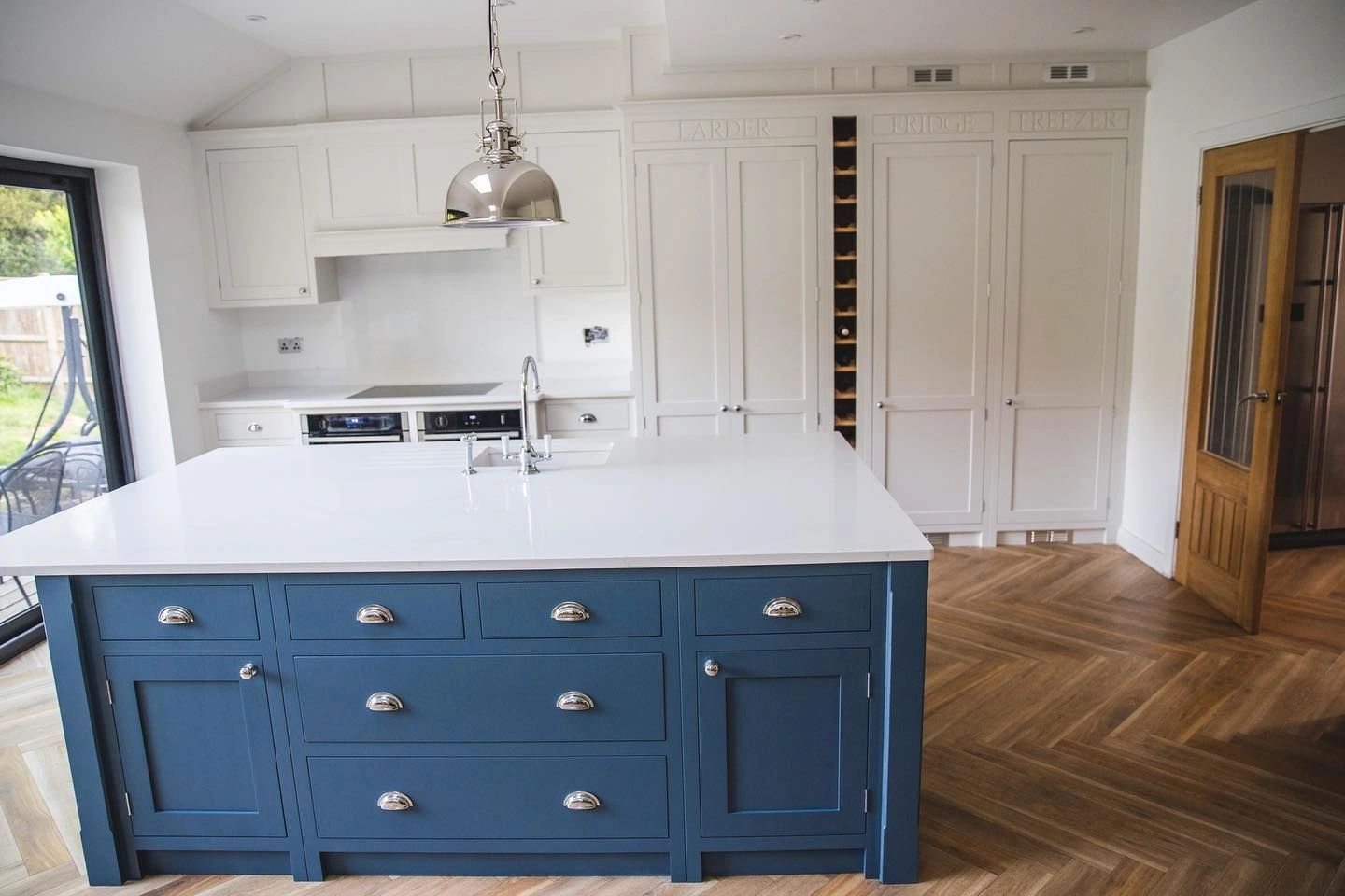Kitchen island finished in blue with light cabinets