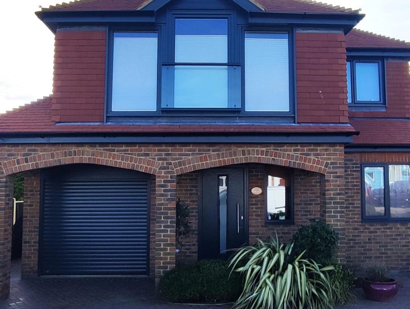 Finished home frontage with dark garage and window frames