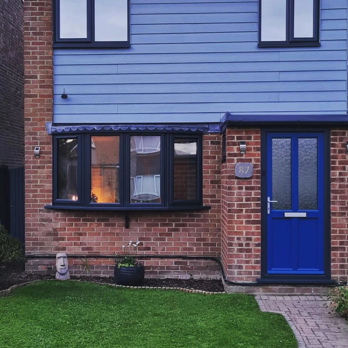Front of house with blue sprayed entrance door and dark windows